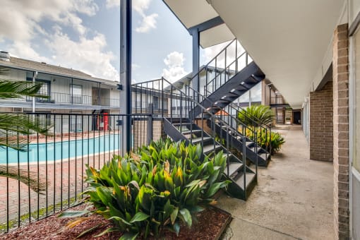 A pool area with a staircase and plants.