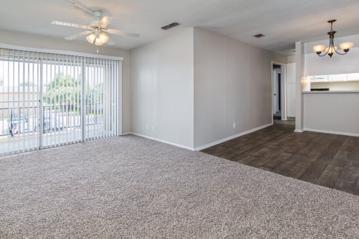 A spacious room with a ceiling fan and a chandelier.