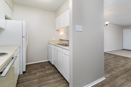 A kitchen with white cabinets and a refrigerator.