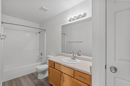 Bathroom with wooden vanity area, single sink, and above-mirror lighting at Eagles Landing, Ammon, ID