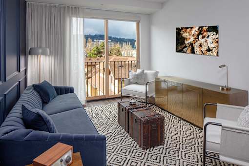 A blue couch sits in a living room with a large window and a view of the city at The Fitz Apartments,Oregon 97210