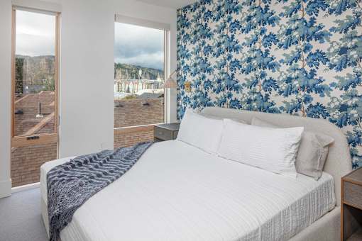 A bedroom with a large bed and a view of the outdoors through the window at The Fitz Apartments,Portland, Oregon