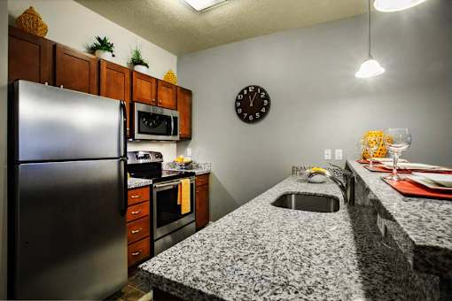 Liberty Gateway Apartments, Salt Lake City, Utah, kitchen with a granite countertop and a clock on the wall.
