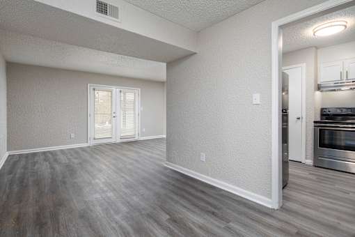 A kitchen area with a stainless steel oven and a doorway leading to another room.