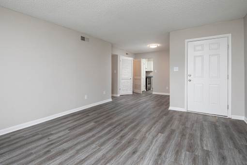 A room with a white door and a grey floor.