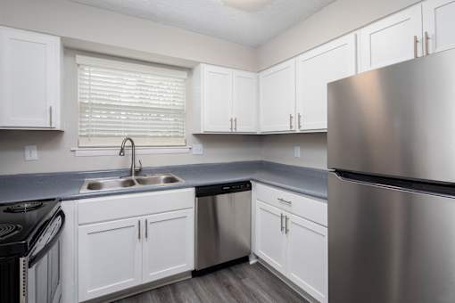 A kitchen with white cabinets and stainless steel appliances.