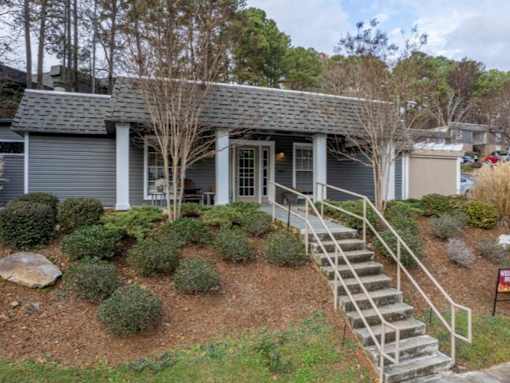 A house with a grey roof and a staircase leading to the front door.