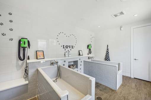 A bathroom with a white tub and a white door at Everra Midtown Park Apartments, Texas, 75231