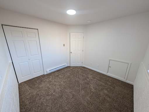 A room with brown carpet and white walls.