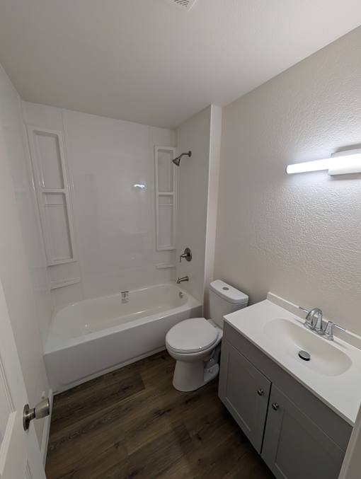 A white bathroom with a toilet, sink, and bathtub.