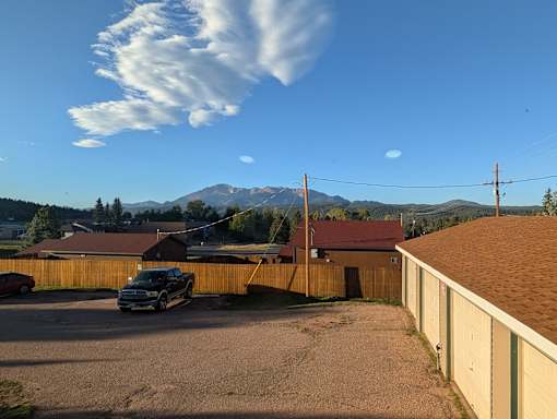 A black car is parked in a driveway.