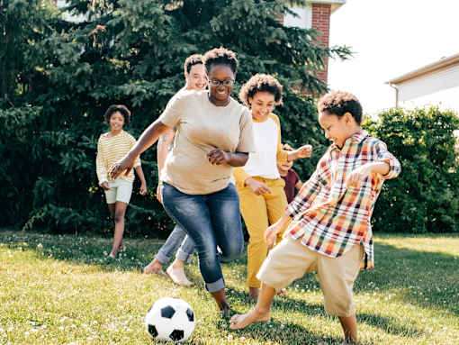 Family having fun playing soccer outside