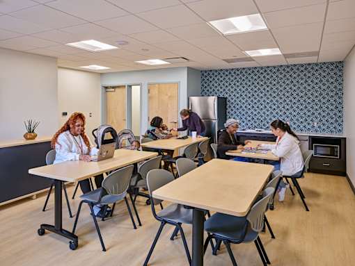 A group of people are sitting around tables in a room.