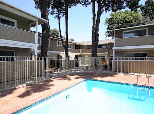 A swimming pool in front of apartment buildings.