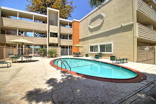 A pool in a courtyard surrounded by buildings.