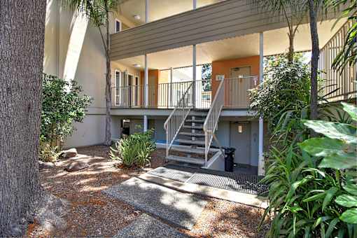 A house with a balcony and stairs leading to it.