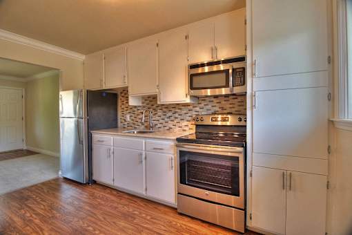 a kitchen with white cabinets and stainless steel appliances