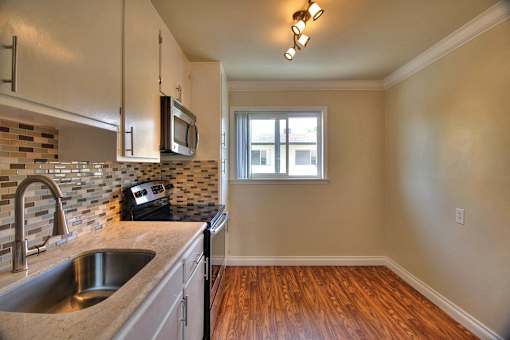 an empty kitchen with a sink and a window