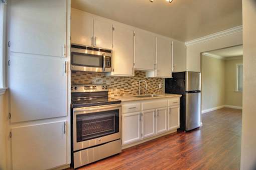 a kitchen with stainless steel appliances and white cabinets
