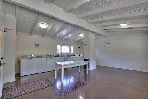 A large, empty room with a table and chairs in the center.