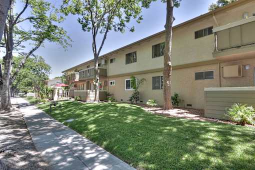 A sunny day at a residential area with apartment buildings and green lawns.