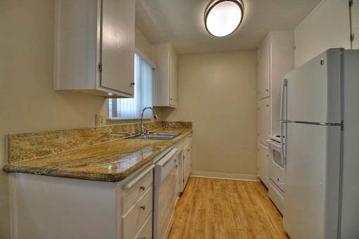 A kitchen with a granite countertop and white cabinets.