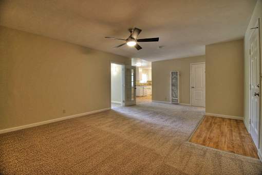 Empty room with a ceiling fan and carpeted floor.