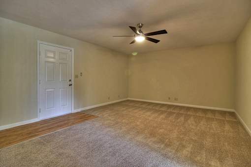 A room with a ceiling fan and a door.