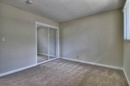 A room with a carpeted floor and a sliding glass door.