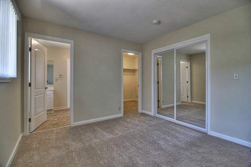 A room with a carpeted floor and a white door.