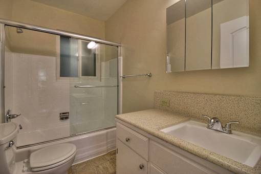 A bathroom with a sink, toilet, and shower.
