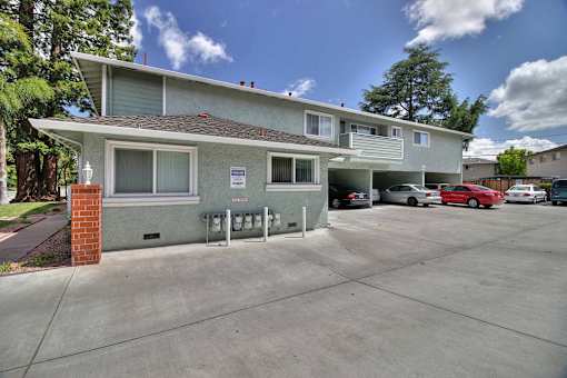 A two-story building with a parking lot in front.