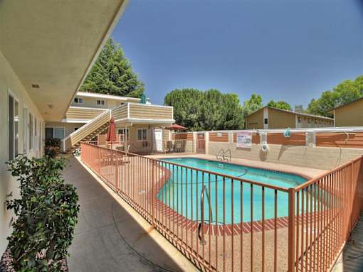 a swimming pool with a wrought iron fence around it