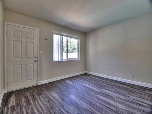 an empty living room with a door and a window