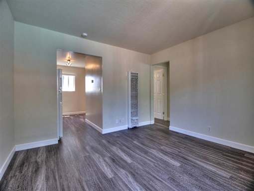 the living room and dining room of an empty house