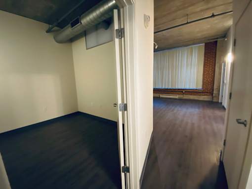 A room with a door and a window with blinds.