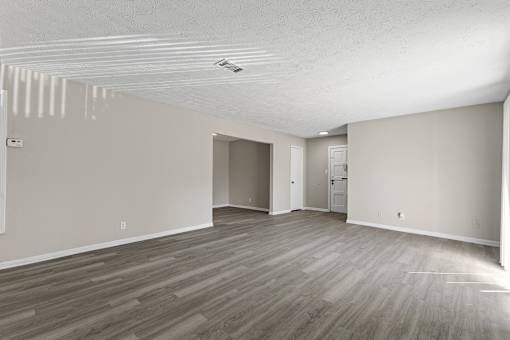 A room with wooden flooring and white walls.