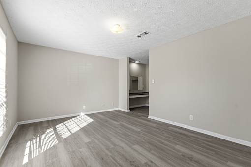 A room with light wood flooring and white walls.