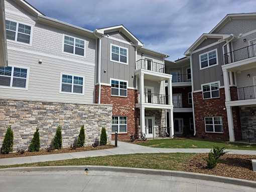 Apartment complex with a mix of stone and brick buildings.