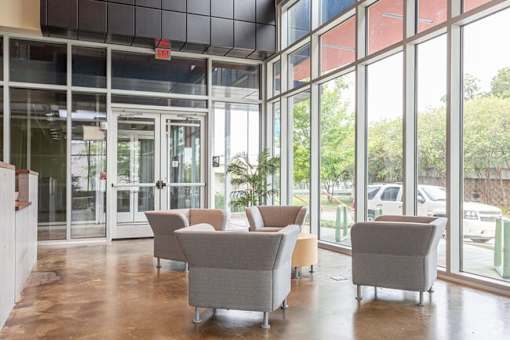 A room with grey chairs and a glass wall.