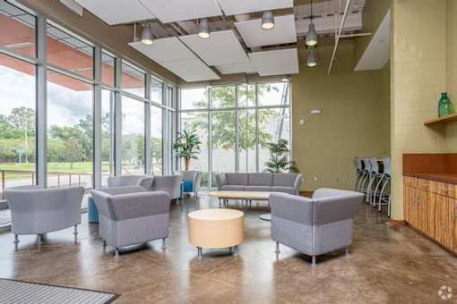 A room with grey chairs and a round table with a white tablecloth.