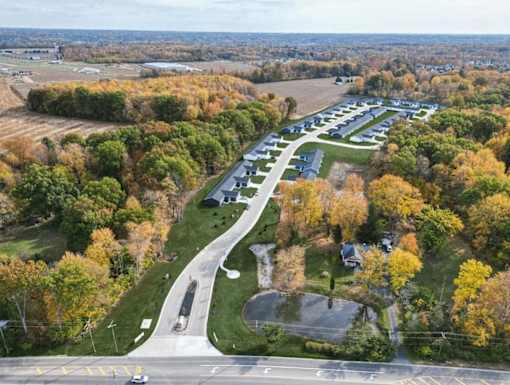 A parking lot is surrounded by trees with autumn leaves.