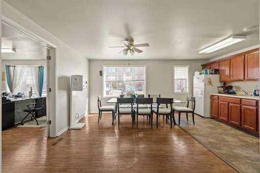A kitchen with a dining table and chairs in the middle of the room.