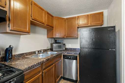 A kitchen with black appliances and wooden cabinets.