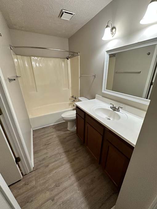 A bathroom with a toilet, sink, and shower.