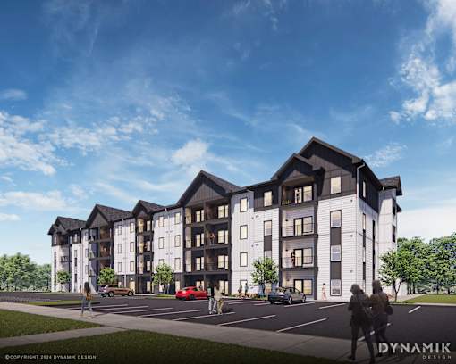 A modern apartment complex with a parking lot in front.