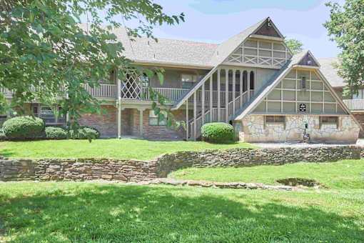 An apartment building with a stone wall in front of it.