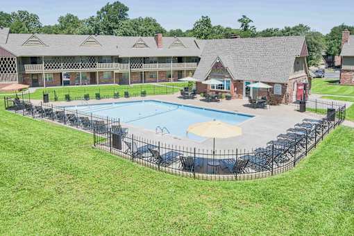A large outdoor swimming pool surrounded by a black fence.
