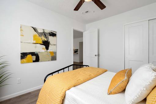 A bedroom with a bed and a painting on the wall.