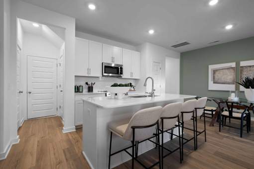 A modern kitchen with white cabinets and a large island.